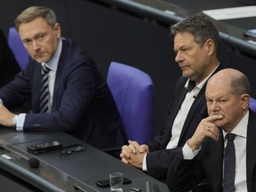 FILE - German Chancellor Olaf Scholz, from right, Economy and Climate Minister Robert Habeck and Finance Minister Christian Lindner listen to a debate about Germany's budget crisis at the parliament Bundestag in Berlin, Germany, Tuesday, Nov. 28, 2023.