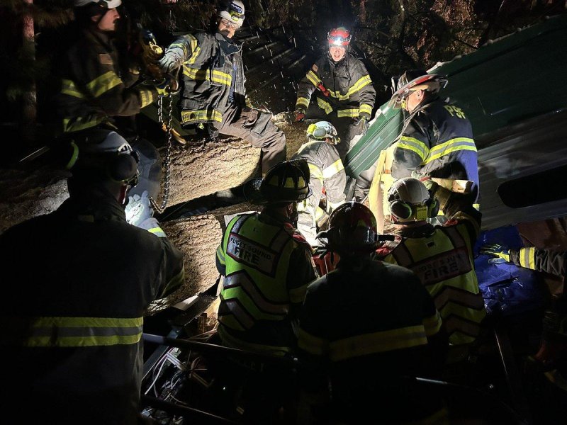 Responders on Tuesday night work to extraciate two people trapped in a trail by a fallen tree in Maple Valley, Wash. Photo courtesy of Puget Sound Fire/X