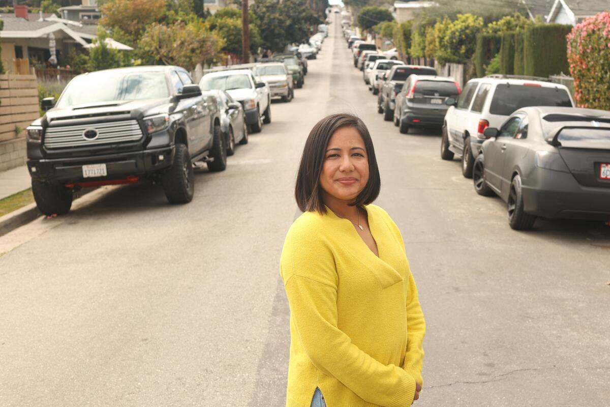 A woman stands in the middle of a street.