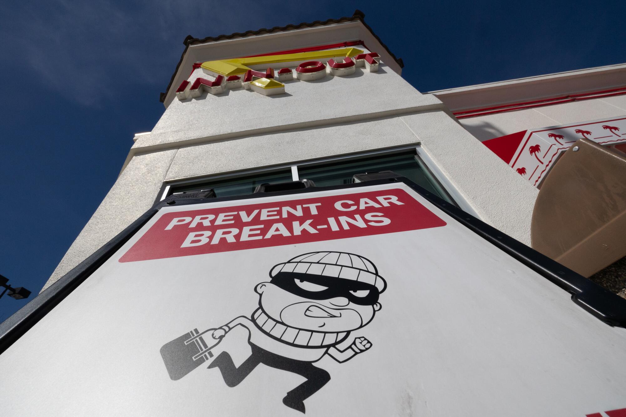  A large warning sign in front of an In-N-Out burger outlet