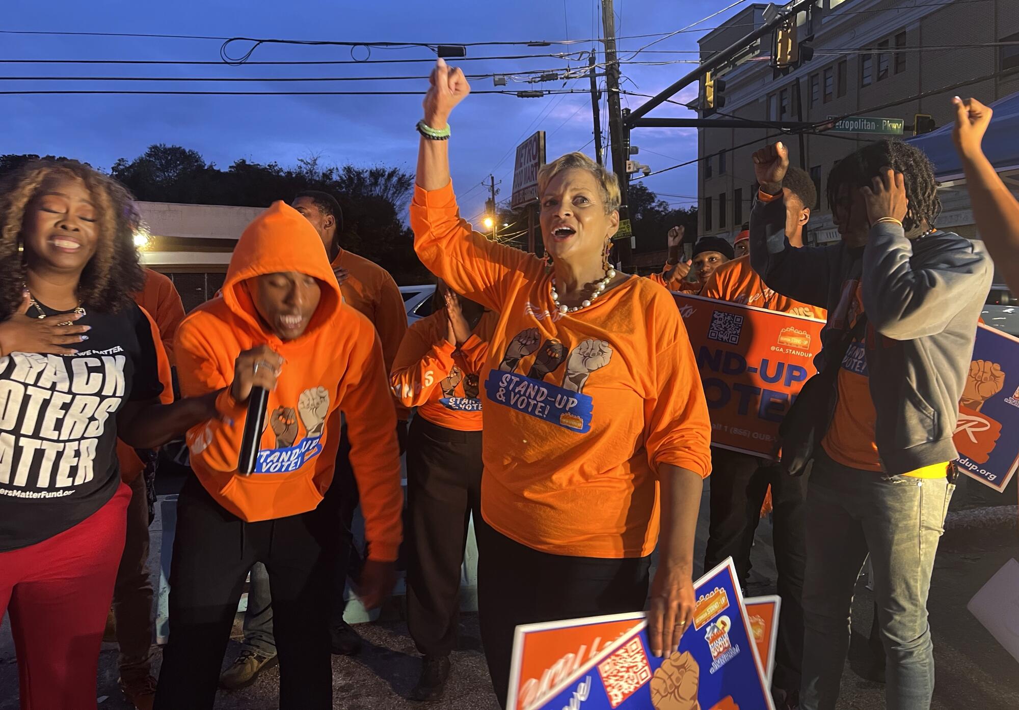 A crowd of activists rallying outside at dark