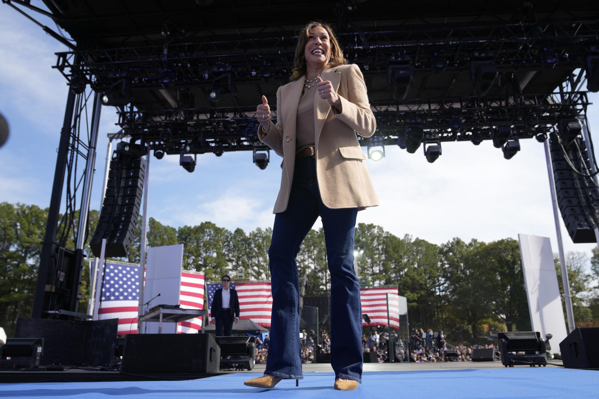 Kamala Harris gives a double thumbs-up onstage