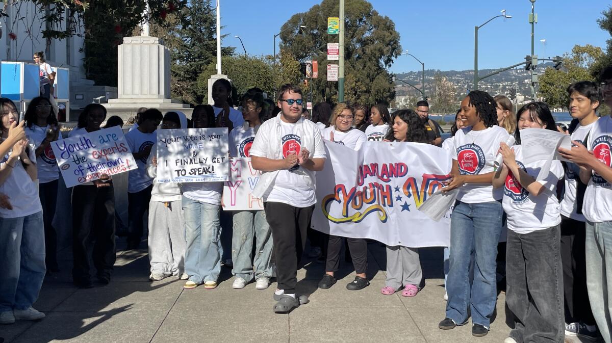 Students hold signs and a banner in celebration