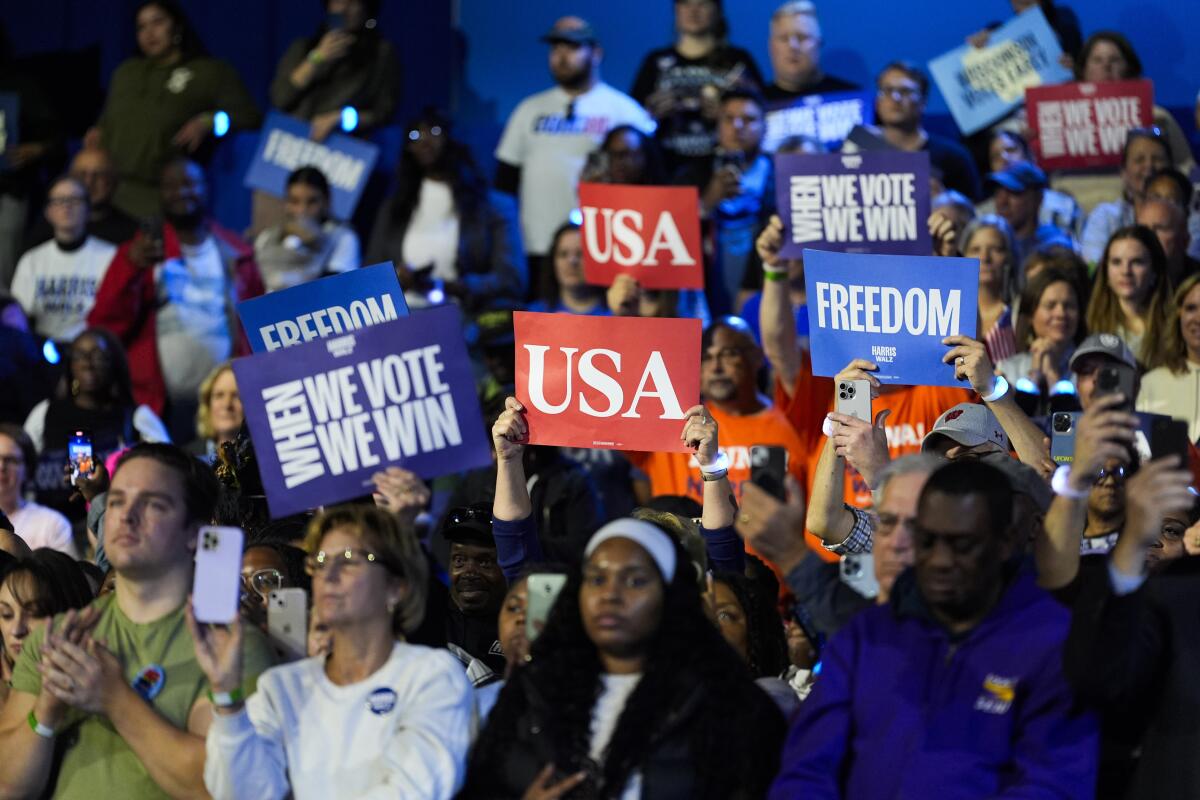 Supporters hold up signs during a campaign rally for Vice President Kamala Harris