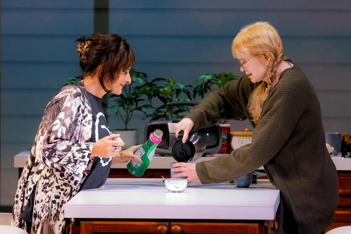 A woman pours coffee into her friend's cup, while the friends holds a bottle of creamer. 