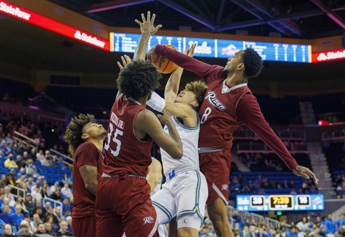 UCLA guard Trent Perry is fouled by Rider forward Tank Byard, right, as he's double teamed by guard T.J. Weeks Jr.