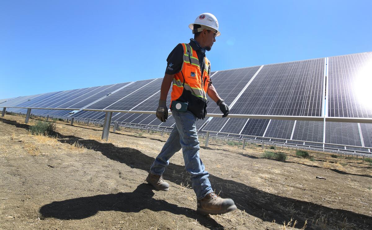 A worker walks across the construction site of a solar project on former farmland in California's San Joaquin Valley in 2021.