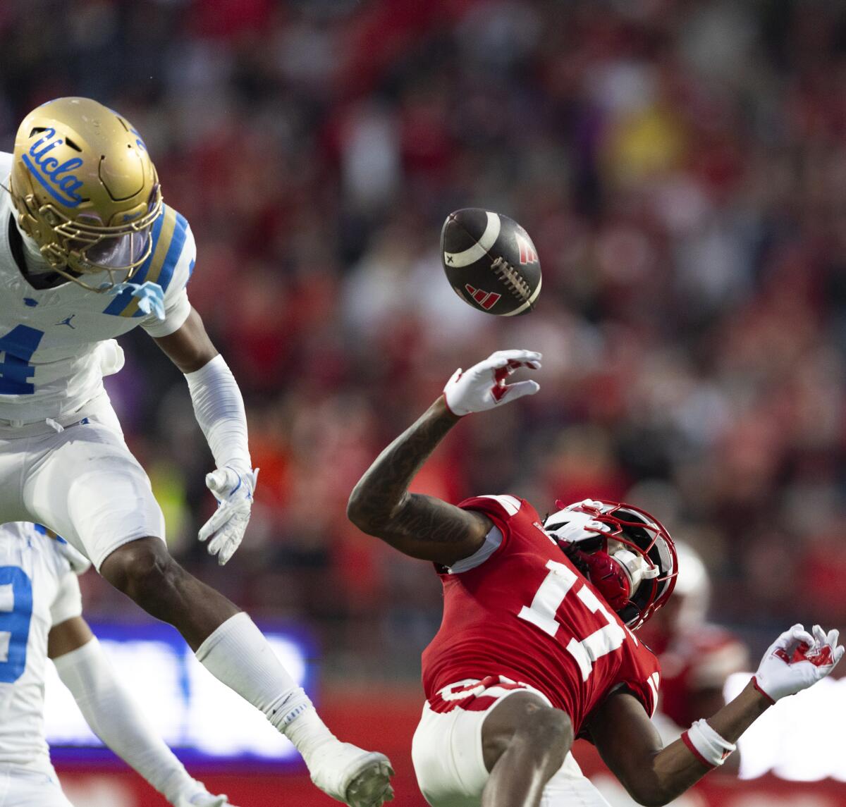 UCLA's Bryan Addison, left, breaks up a pass intended for Nebraska's Jacory Barney Jr., which was then intercepted.