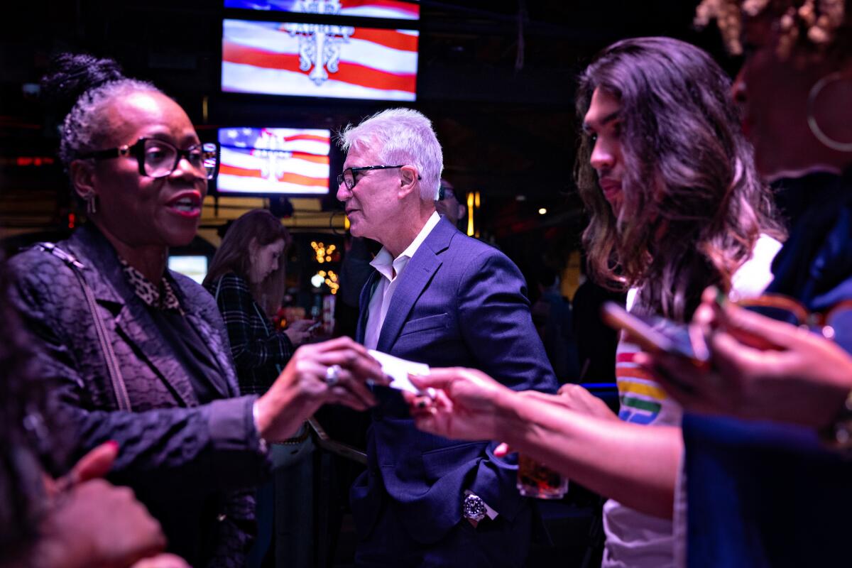 George Gascón and others mingle in a dark club