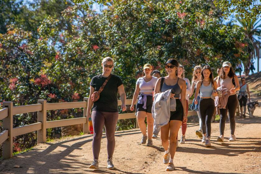 Los Angeles, CA - Monica Figueroa, middle, walks with a group of young women at Runyon Canyon Park on Saturday, Nov. 12, 2022, in Los Angeles, CA. Figueroa helps organize LA Girls Who Walk, which is a new group that organizes walking events for women for the sole purpose of making new friends. The group started in San Diego and later expanded to L.A., but has grown so popular that people have started spinoffs in their own neighborhoods using a Discord chat community. (Francine Orr / Los Angeles Times)