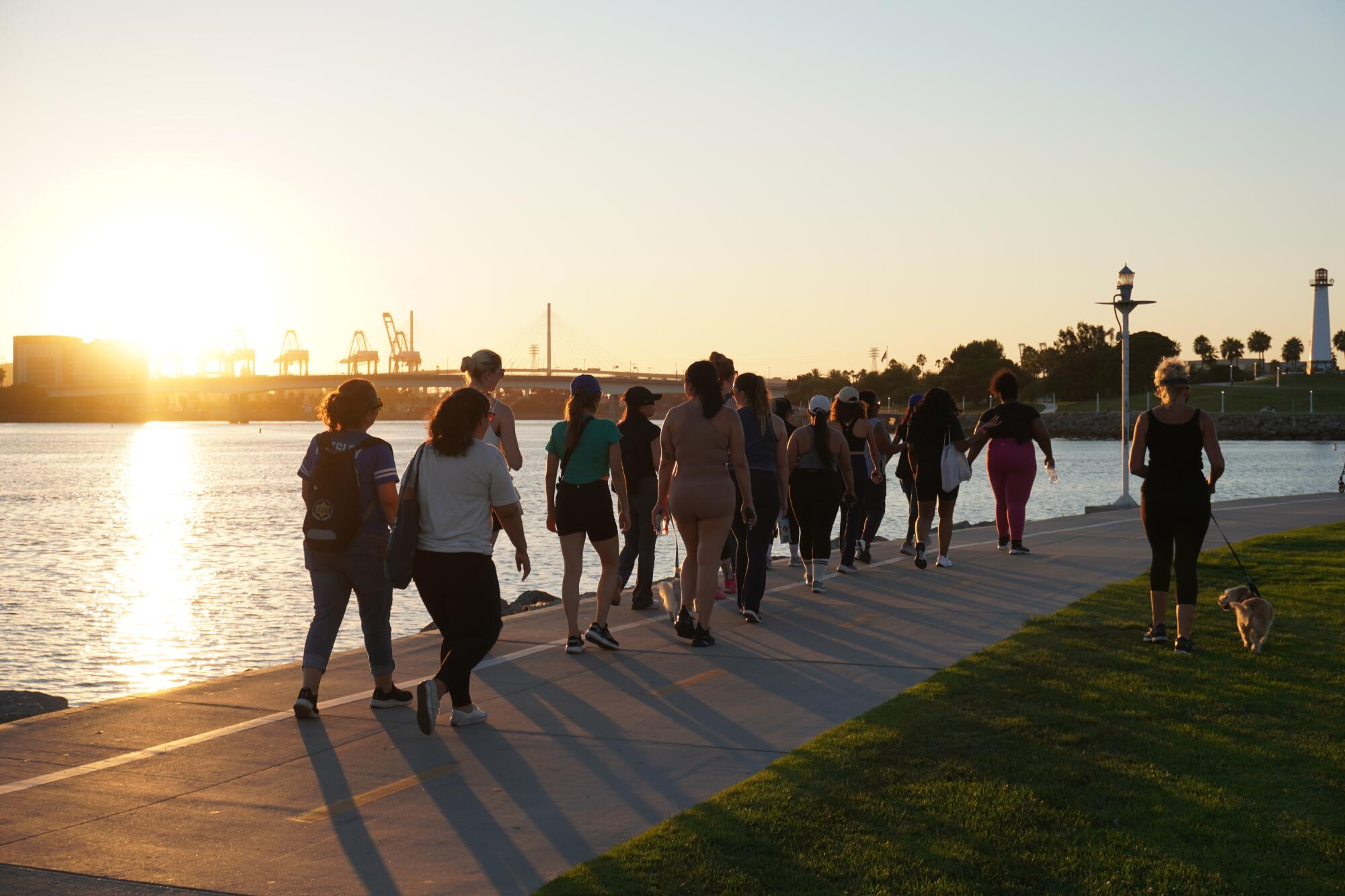 Long Beach Walking Club members walk along the waterfront as the sun sets