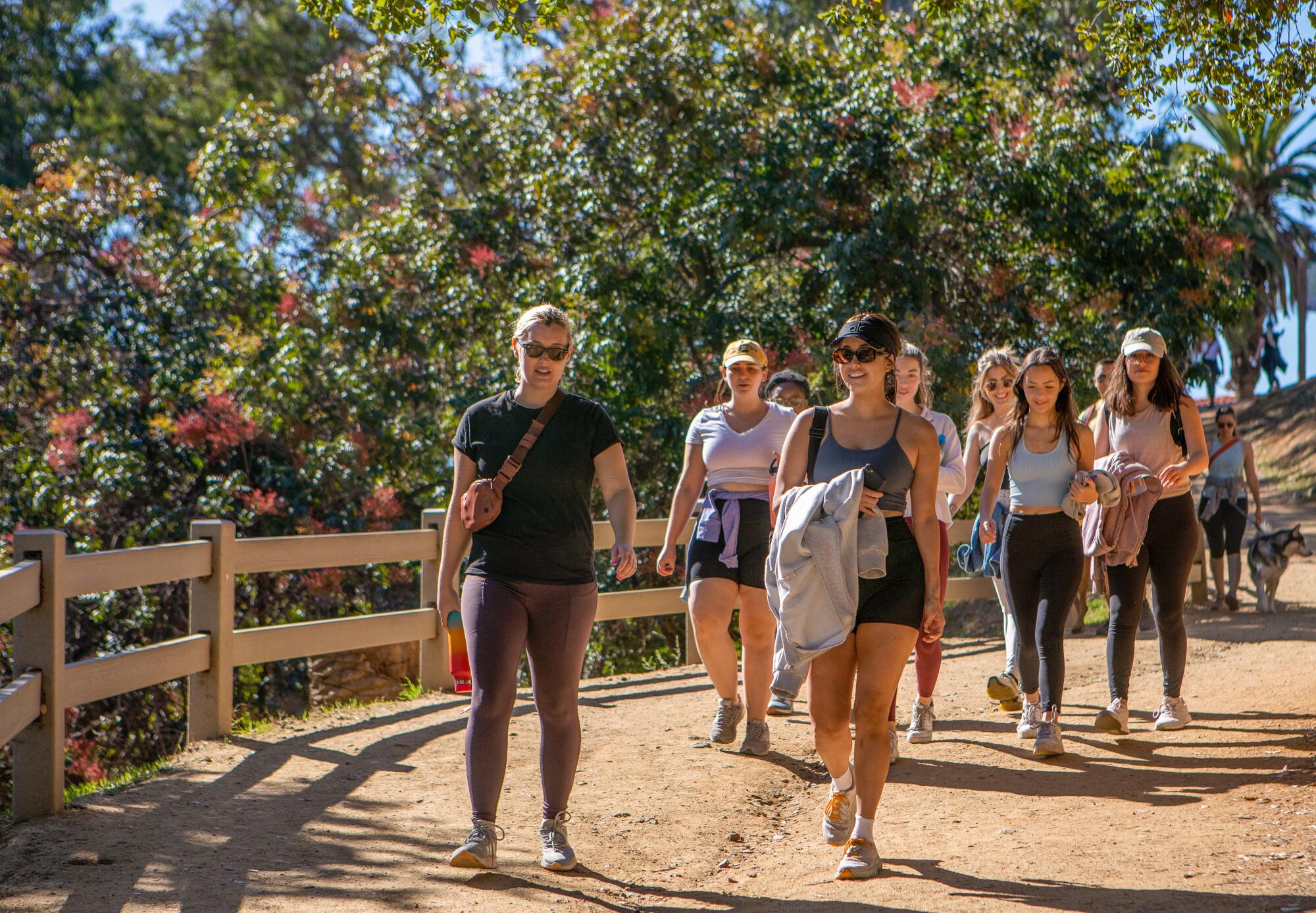 L.A. Girls Who Walk members on a dirt trail with a low wooden fence along it