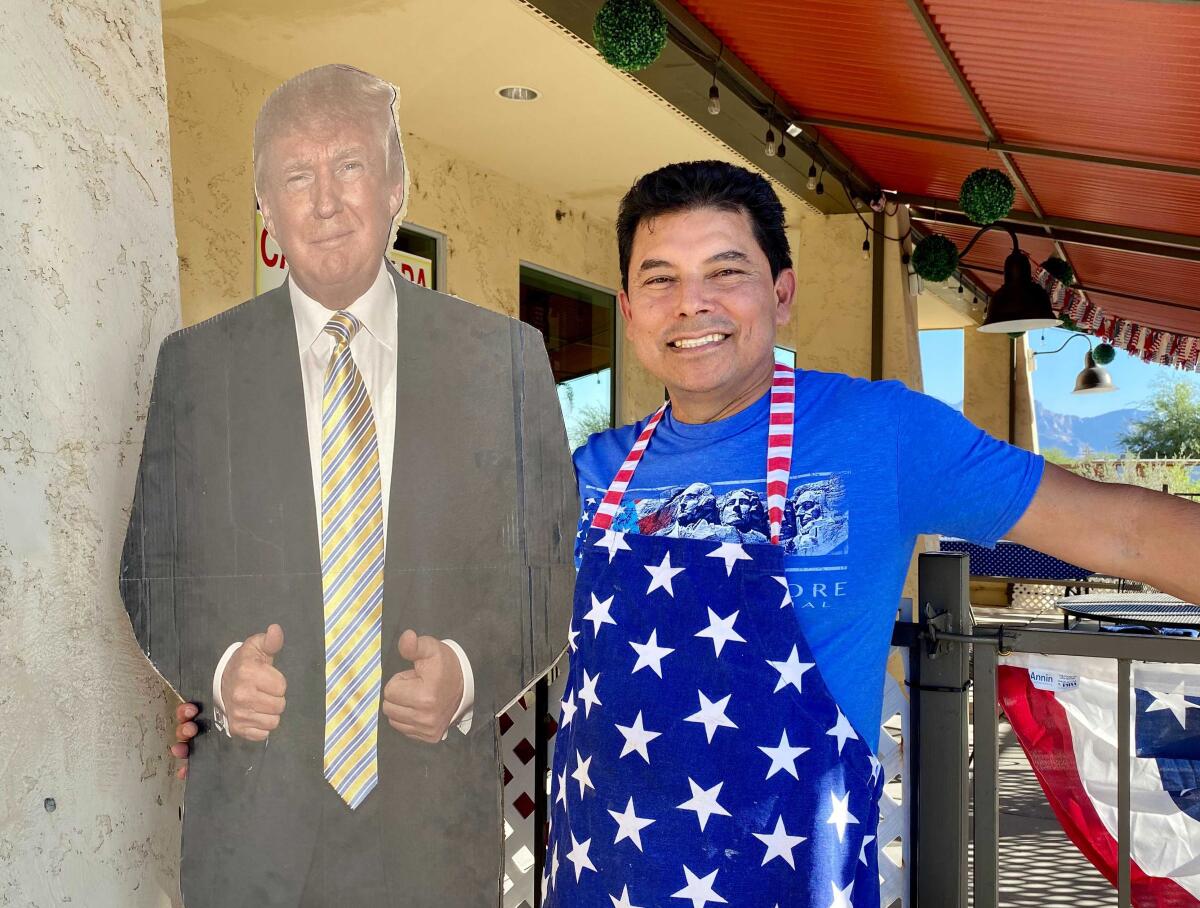 A man with a cardboard cutout of Donald Trump