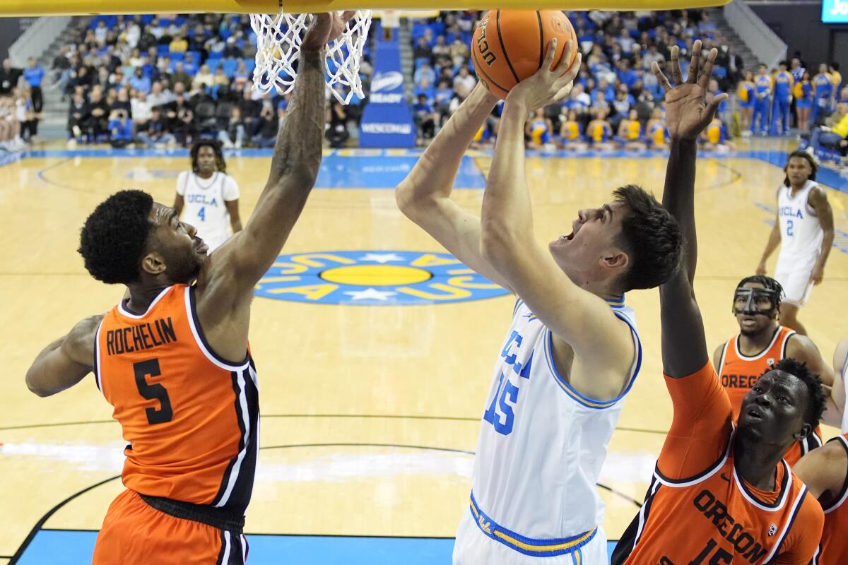 UCLA center Aday Mara shoots under pressure from Oregon guard Justin Rochelin, left, and center Chol Marial on Feb. 1