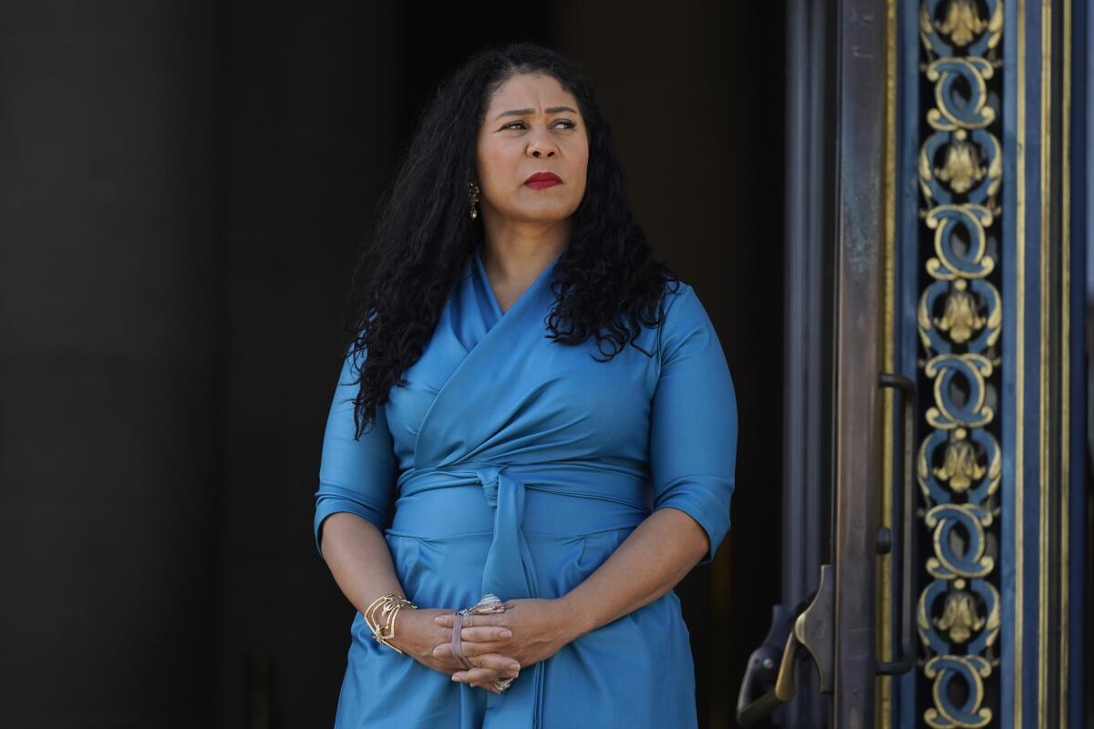 San Francisco Mayor London Breed listens pensively during a briefing outside City Hall.