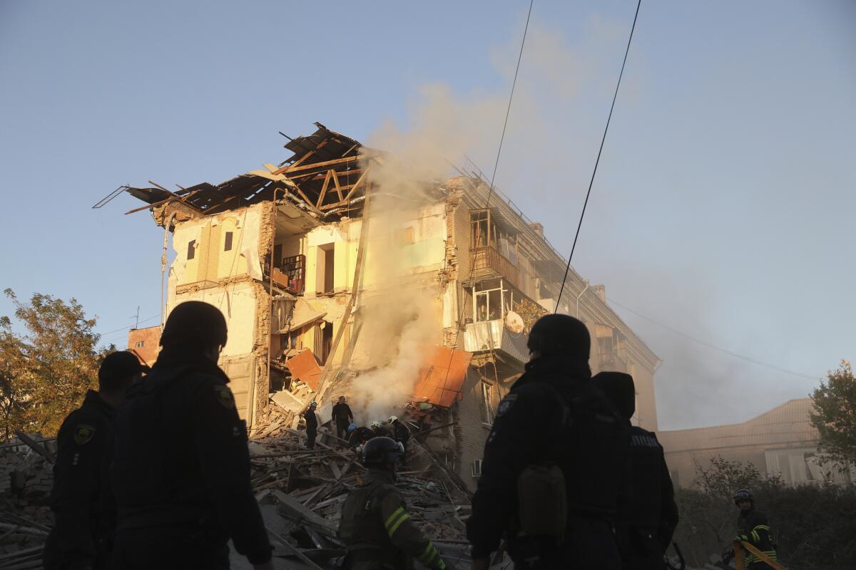 Rescue workers in Ukraine clear the rubble of a residential building destroyed by a Russian airstrike.