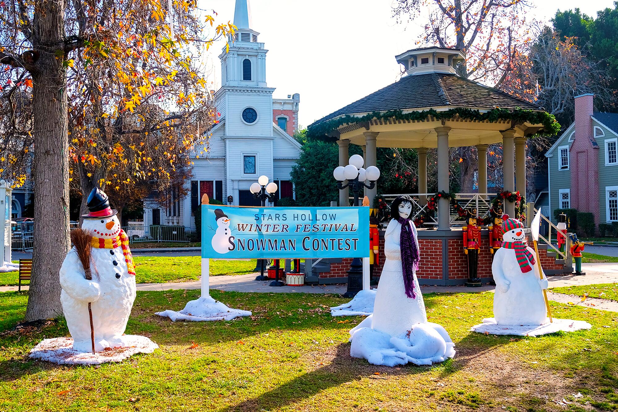 Multiple snowman surrounding a gazebo.