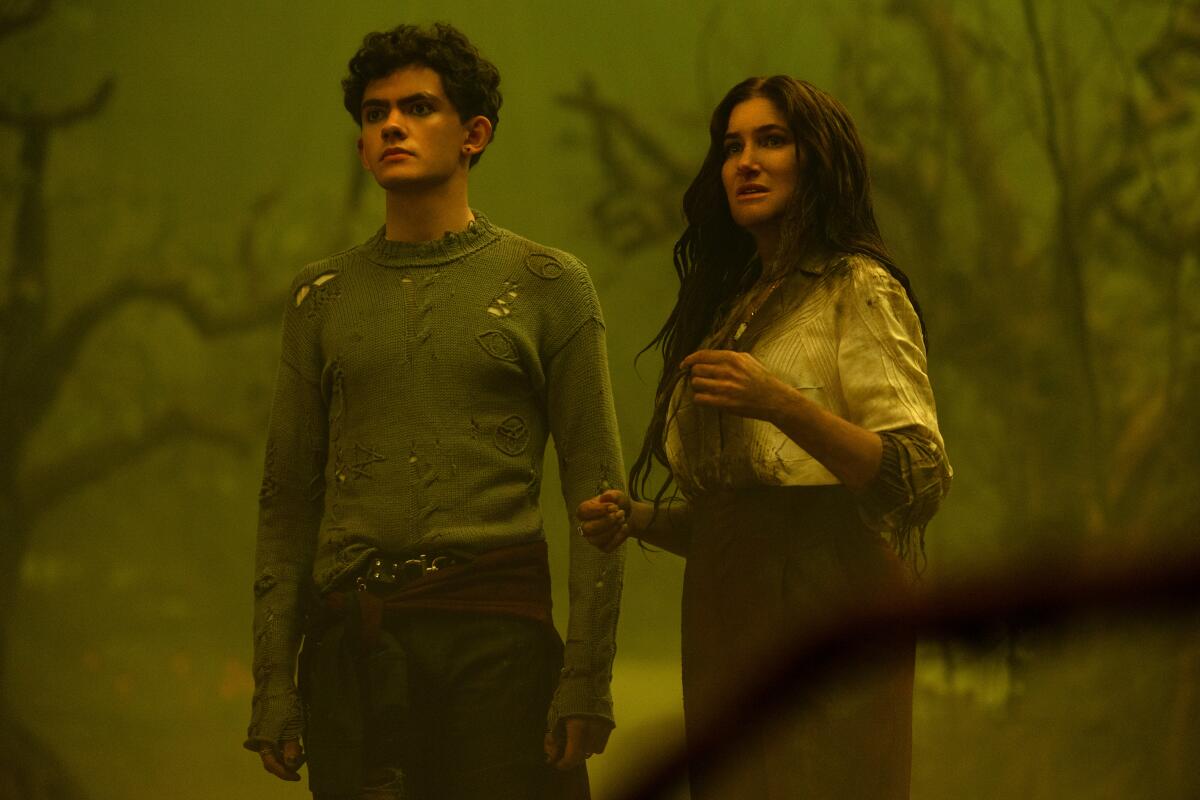 A teenage boy and a woman looking a bit disheveled in a foggy forest