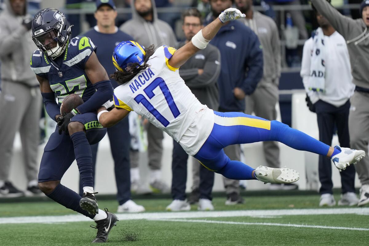 Seahawks cornerback Riq Woolen intercepts a pass intended for Rams receiver Puka Nacua (17).