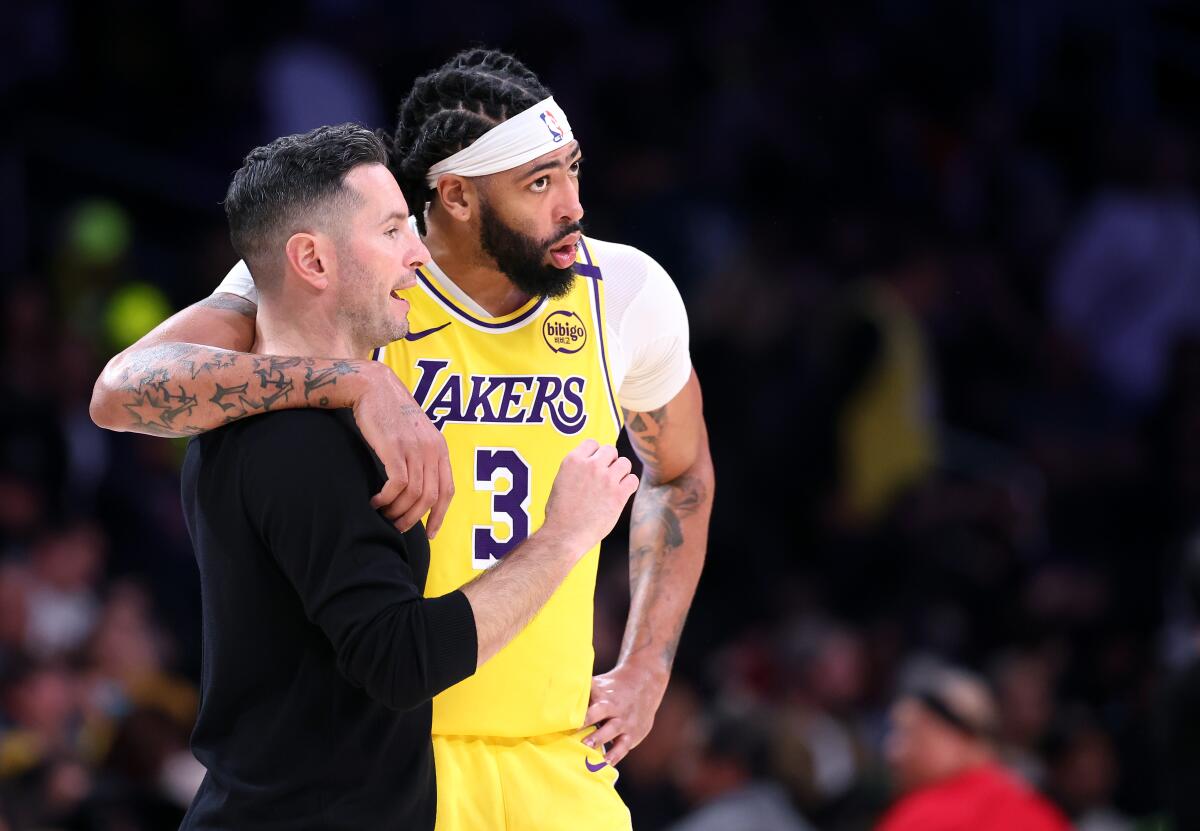 Lakers coach JJ Redick and Anthony Davis talk on the sideline during a win over the 76ers at Crypto.com Arena Friday.