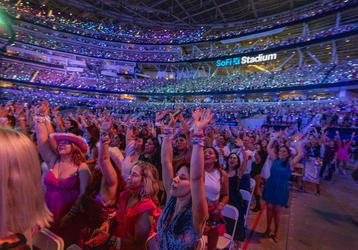 Fans watch Taylor Swift perform on stage.