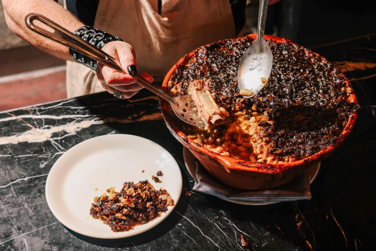 Chef David Campigotto serves a plate of his cassoulet at Chi Spacca