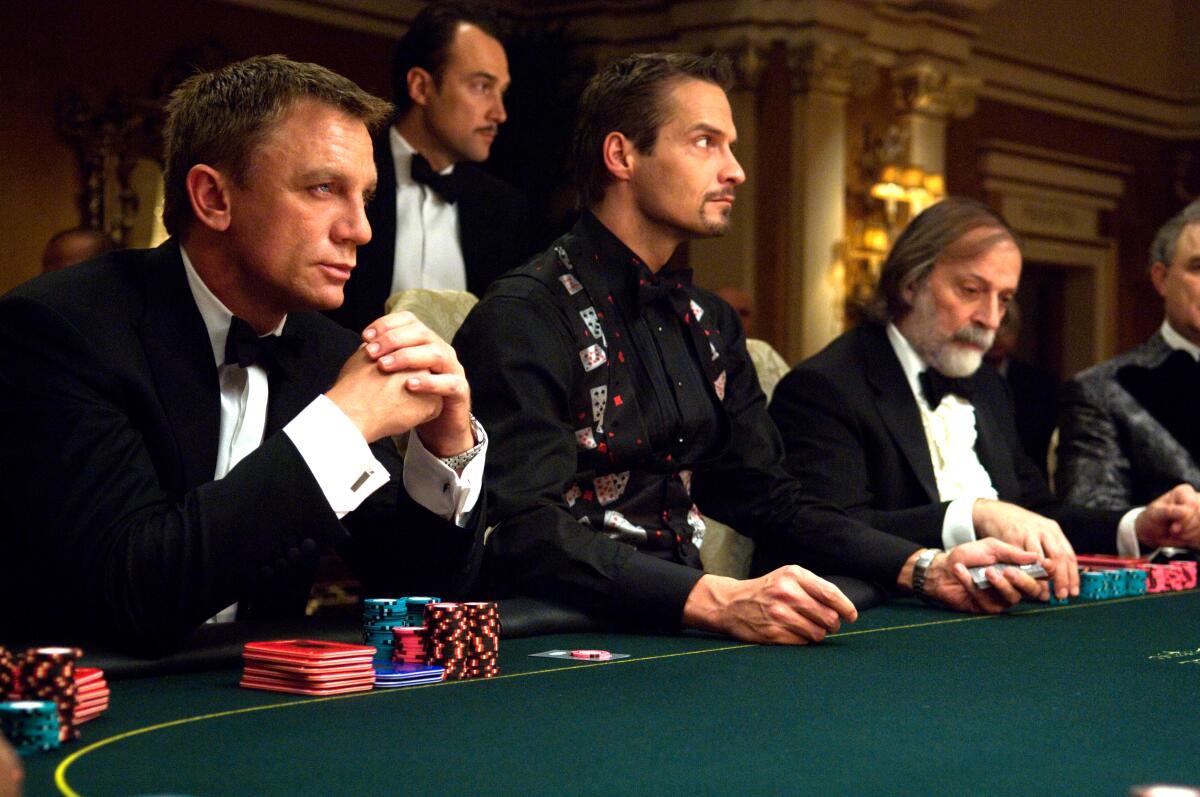 Men in tuxedos gamble at a green felt table.