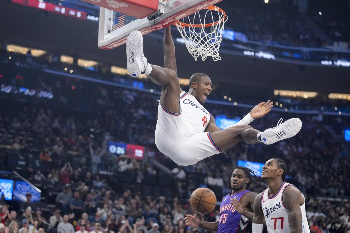 Clippers guard Kris Dunn celebrates after dunking against the Raptors in the first half Saturday.