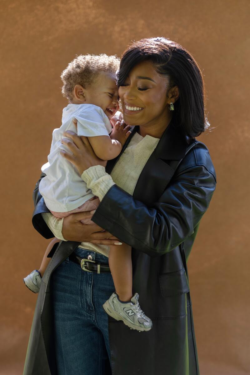 Keke Palmer outdoors holding her toddler son.