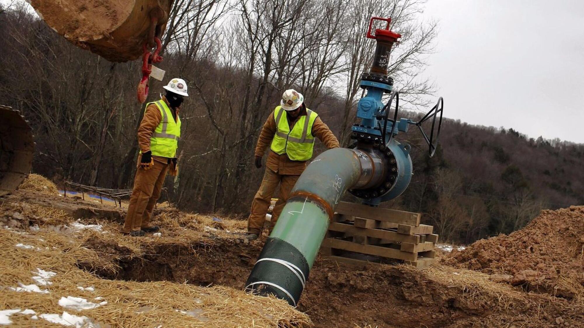 Men work on a natural gas valve at a fracking site in South Montrose, Pa.