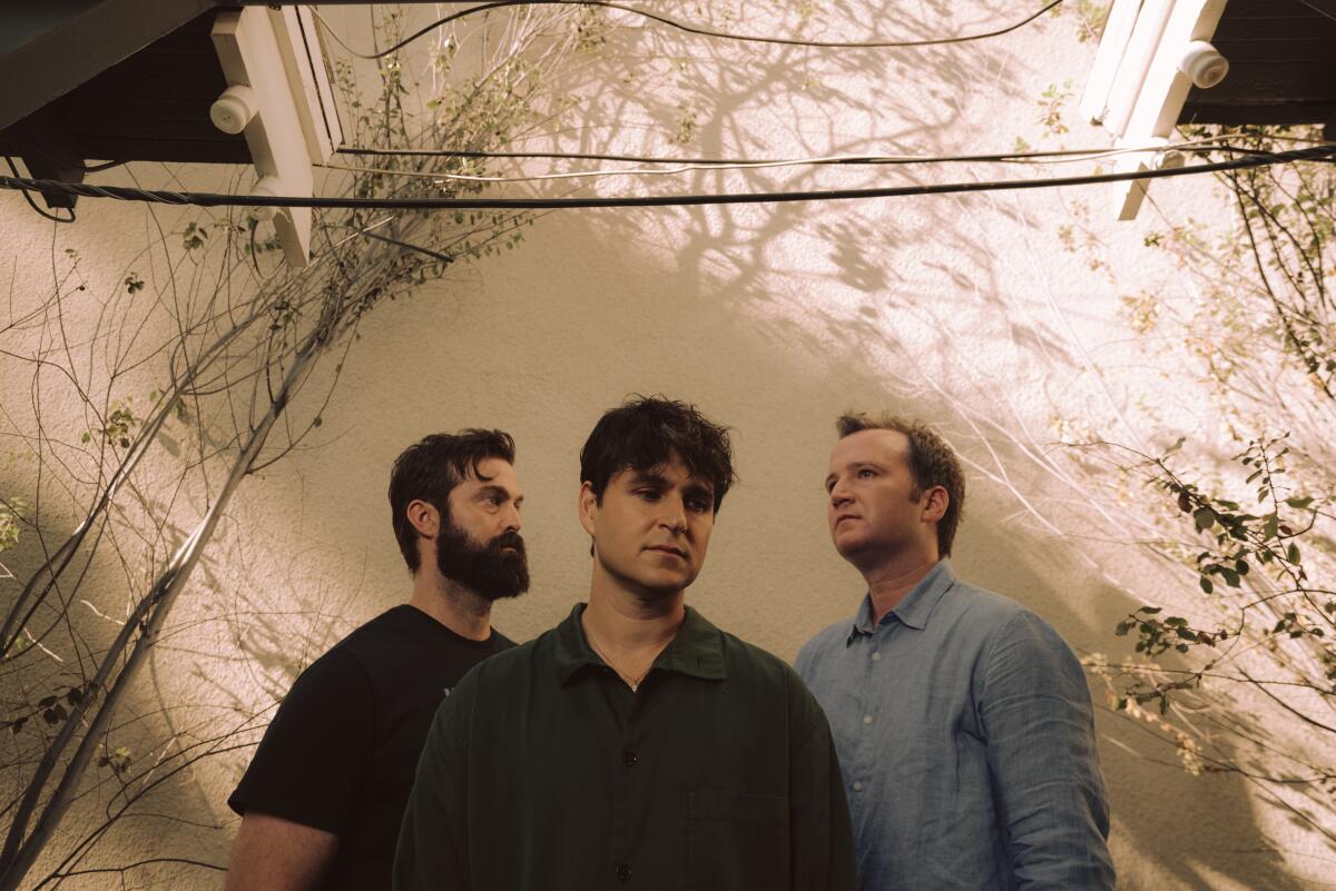 Vampire Weekend's Chris Tomson, Ezra Koenig and Chris Baio stand outside a house