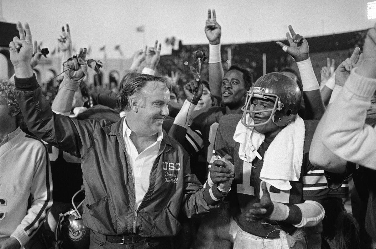 USC Trojans coach John Robinson congratulates his player Charles White (12) after they trounced.