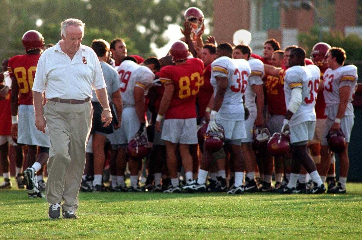 John Robinson walks on the field during a USC practice session in 1995.