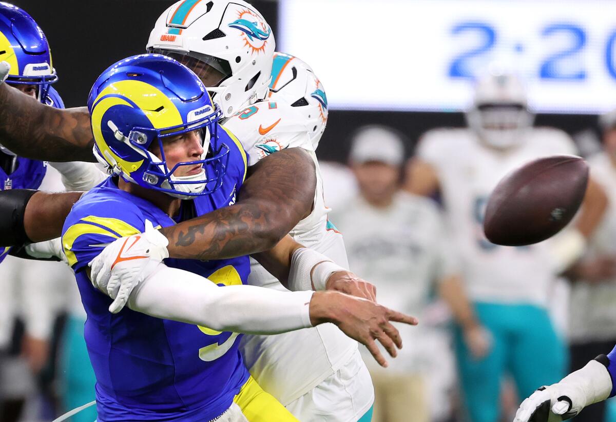 Rams quarterback Matthew Stafford throws an incomplete pass as Dolphins defensive tackle Neil Farrell puts pressure on.