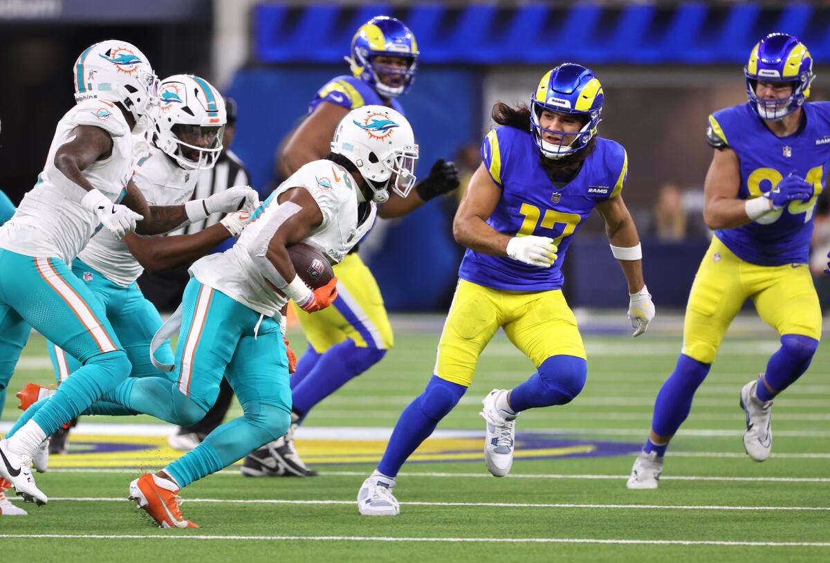 Dolphins cornerback Kendall Fuller picks up a fumble by Kyren Williams as the Rams' Puka Nacua, second from right, pursues. 