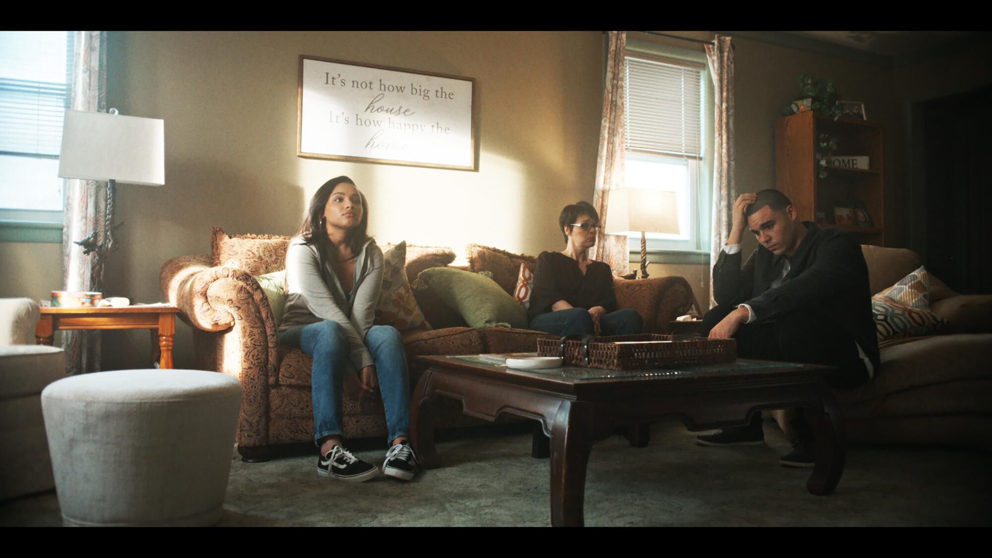 Three people sitting on couches in a living room.