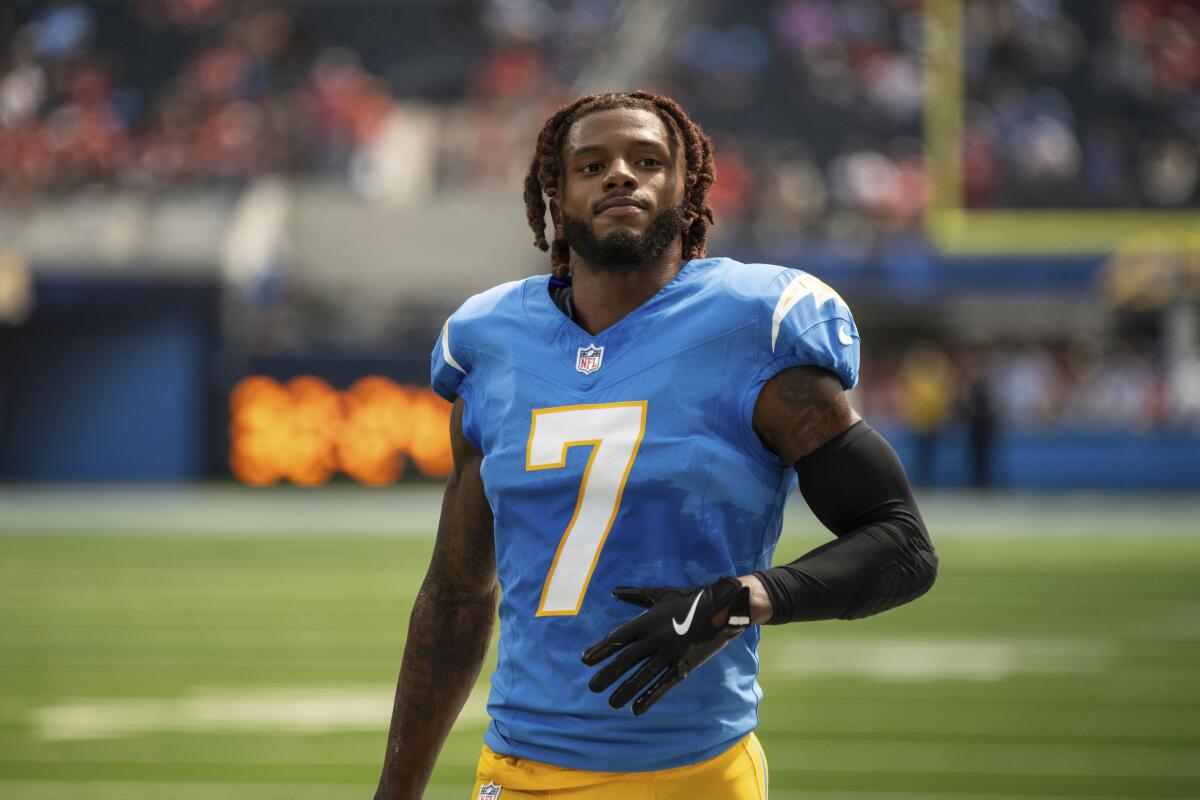 Chargers cornerback Kristian Fulton (7) walks on the field with his helmet off before a game.