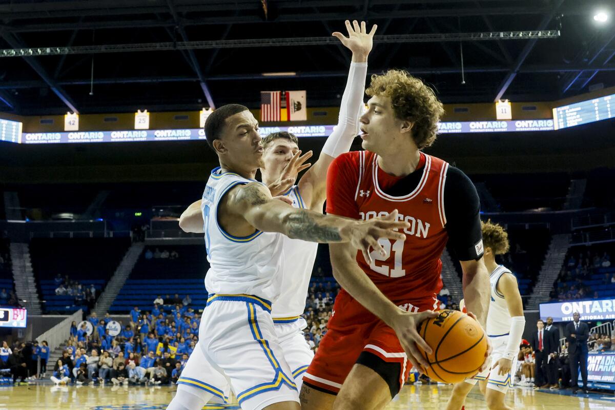 Boston University's Nico Nobili vies for the ball in front of UCLA's Kobe Johnson and Tyler Bilodeau 