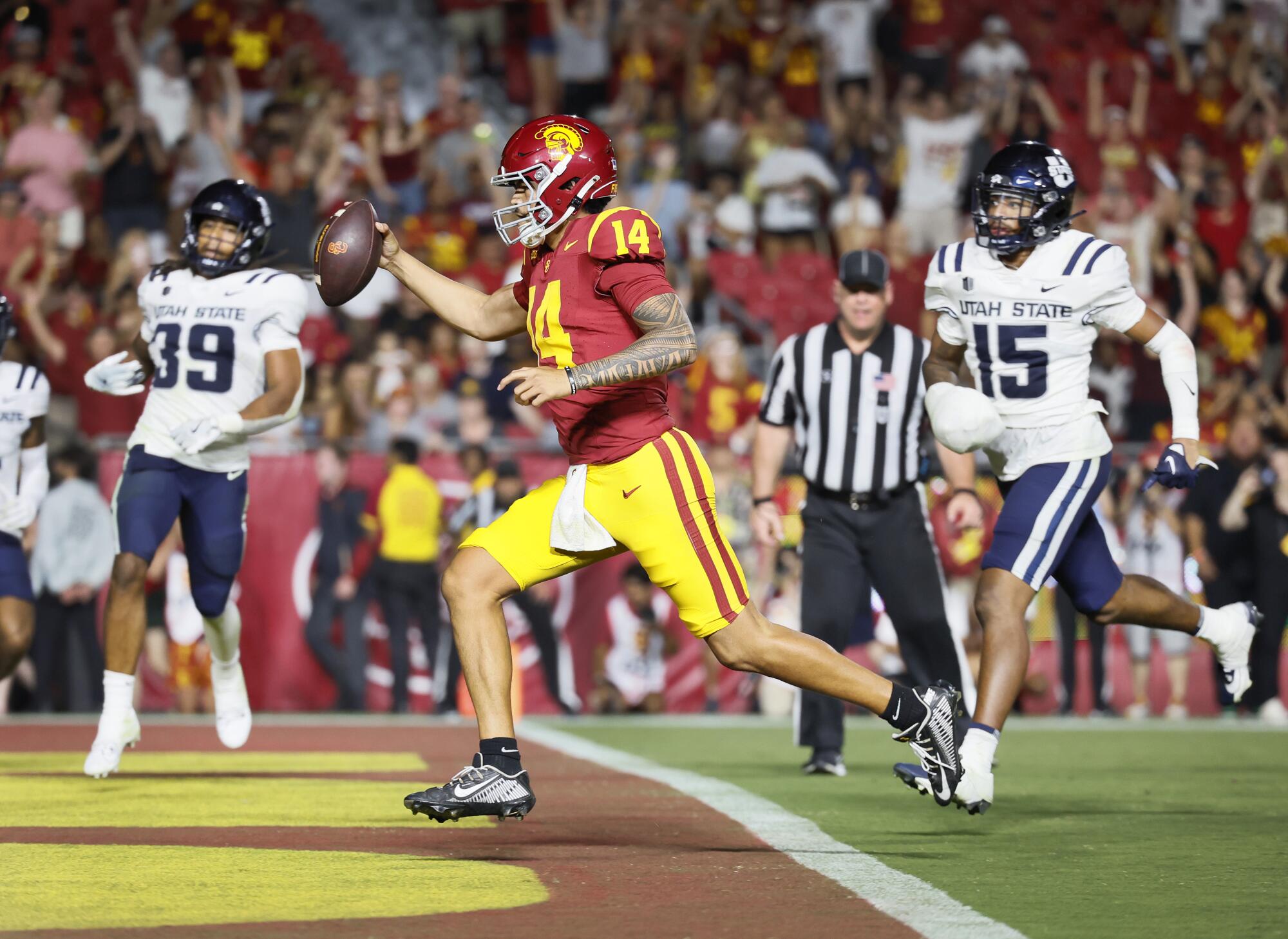 USC quarterback Jayden Maiava holds up the ball as he runs into the end zone in front of Utah State players on Sept. 7.