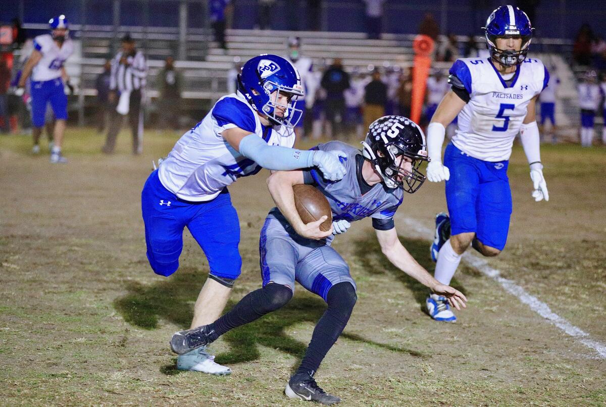 Palisades linebacker Nico Townsley, left, tackles North Hollywood quarterback Nate Arlauskas.