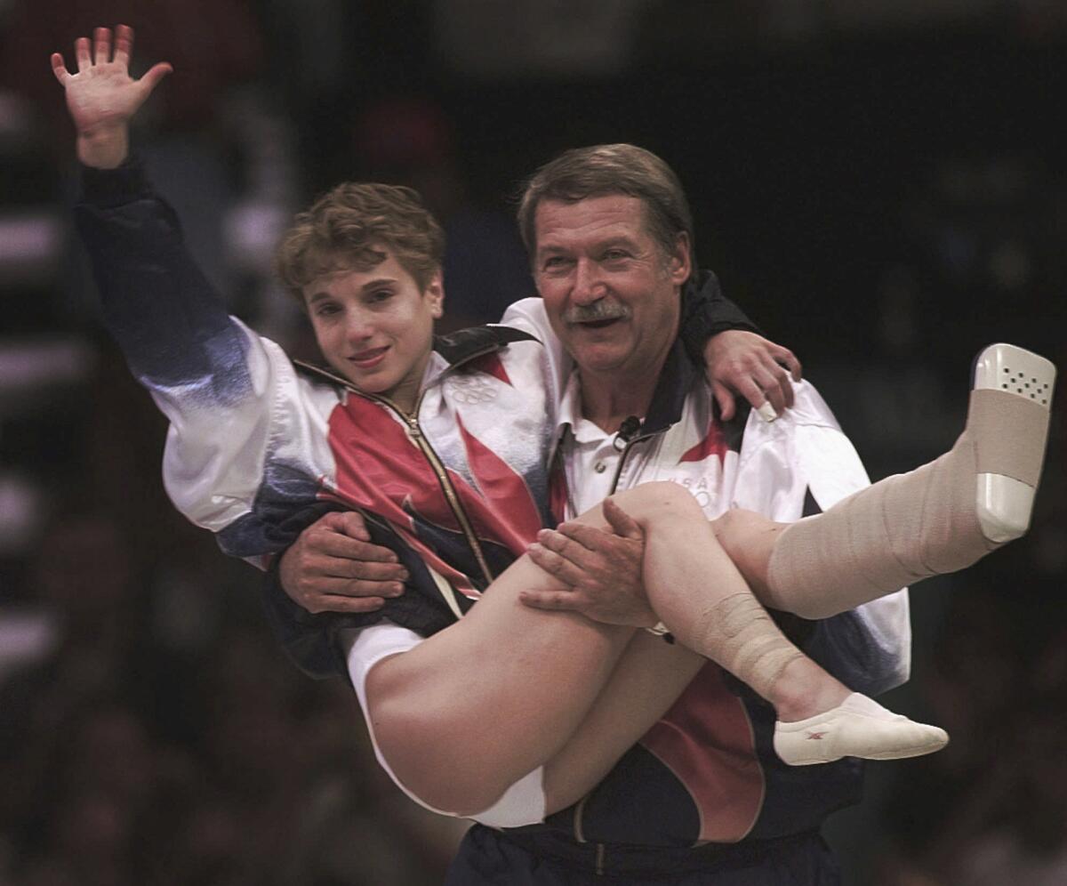 Bela Karolyi carries Kerri Strug after she helped the U.S. win team gold at the 1996 Atlanta Olympics.