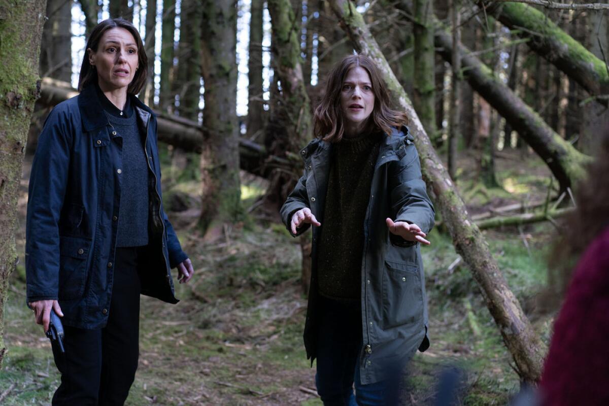 Two women confront a third person in a copse of trees