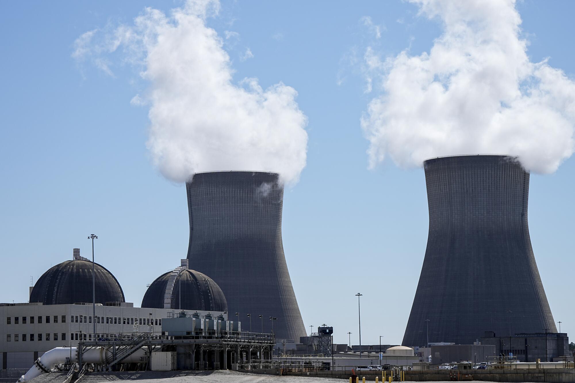 Steam rises from two nuclear cooling towers. 