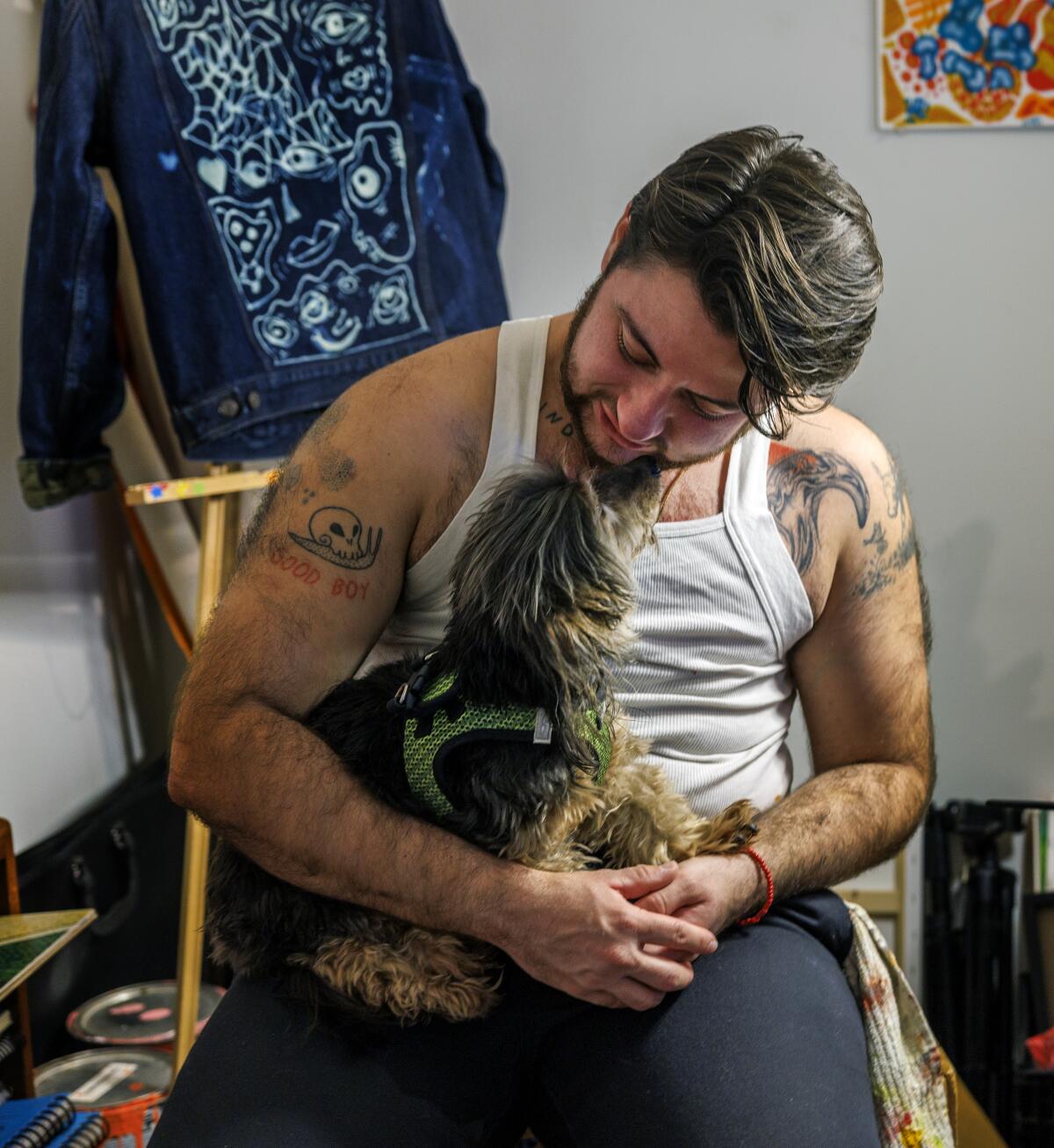 Mars Wright sits in a small studio space in his apartment with his elderly dog Lucy.