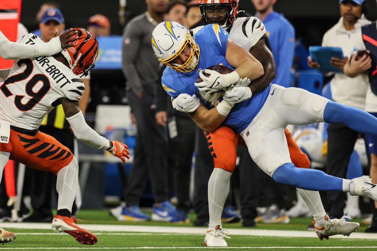 Chargers tight end Will Dissly is spun in the air after a reception on the tackle of Bengals cornerback Cam Taylor-Britt.