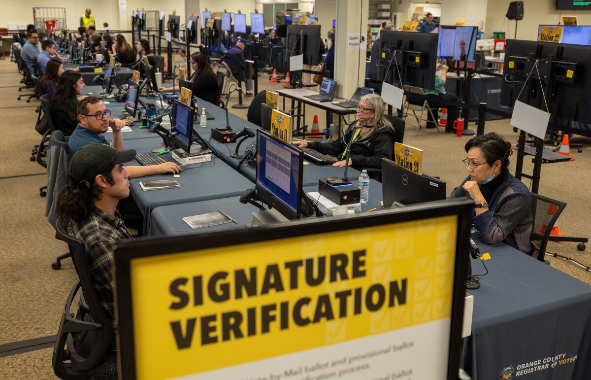 Election workers verify signatures on ballots at the Orange County Registrar of Voters.