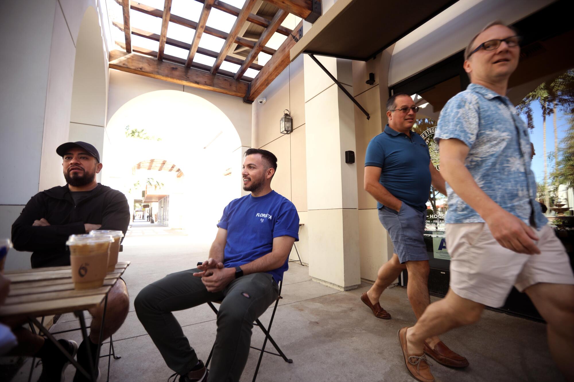 Steven Garcia, left, co-owner of Sixth Street Coffee, enjoys a cup of coffee with friend Sesar Orozco.