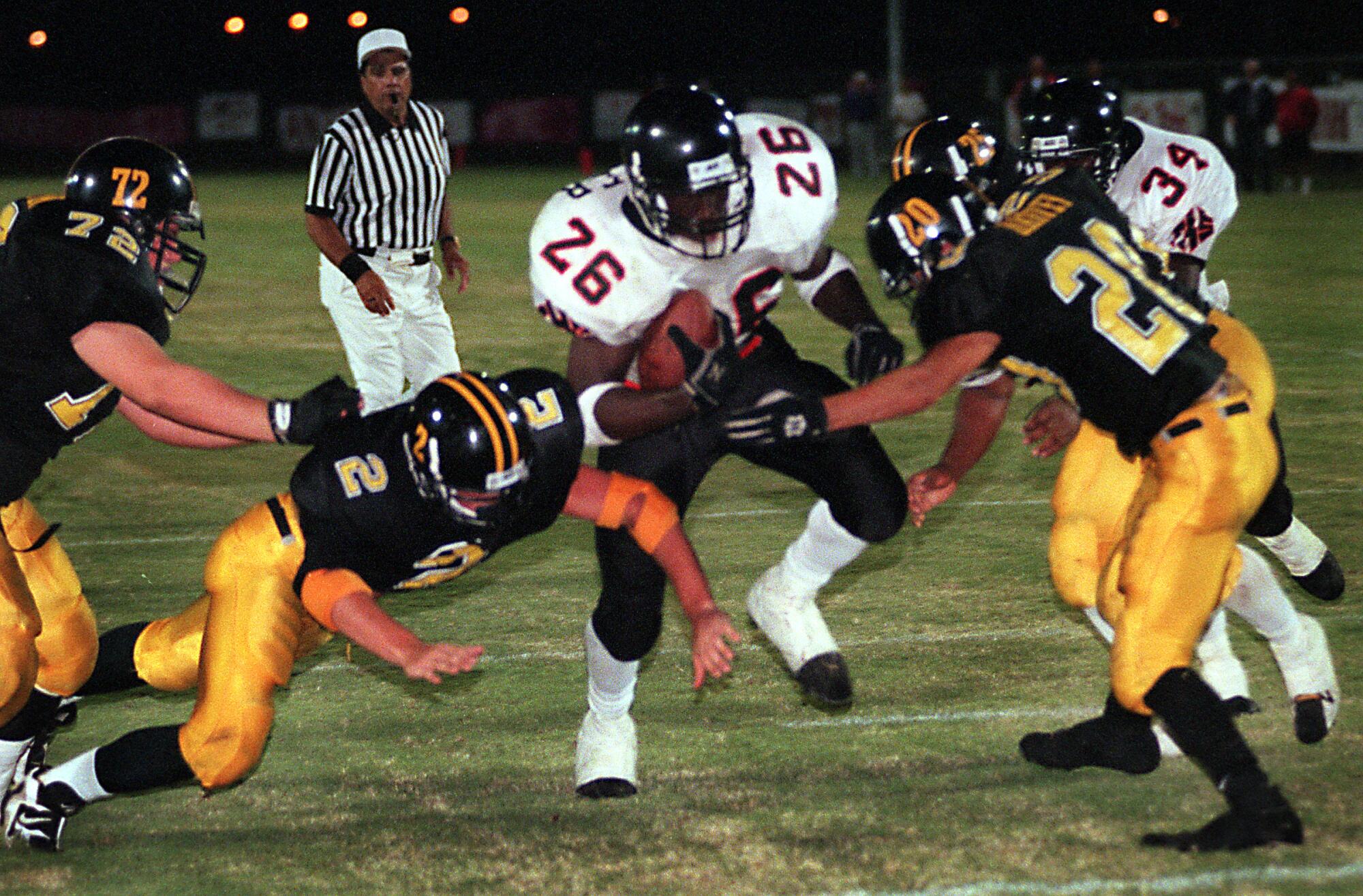 Tustin High tailback DeShaun Foster runs past Foothill's Eric Davidson, Dana Pino-Dempsey and Joshua Harvey.