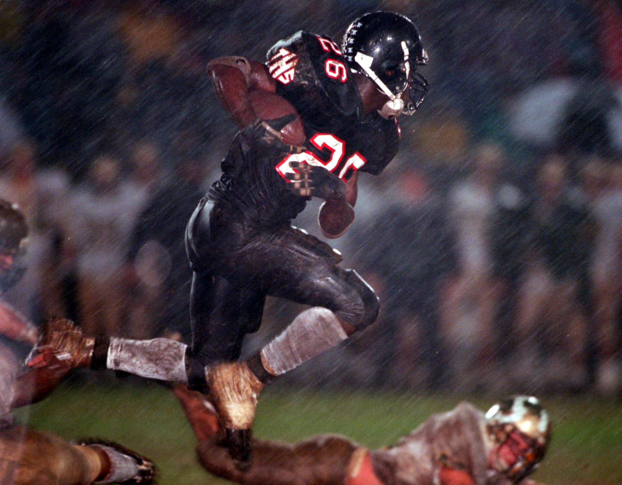 Tustin High's DeShaun Foster gets jumps as Brea Olinda tries to tackle him by his shoestring during a  wet game.