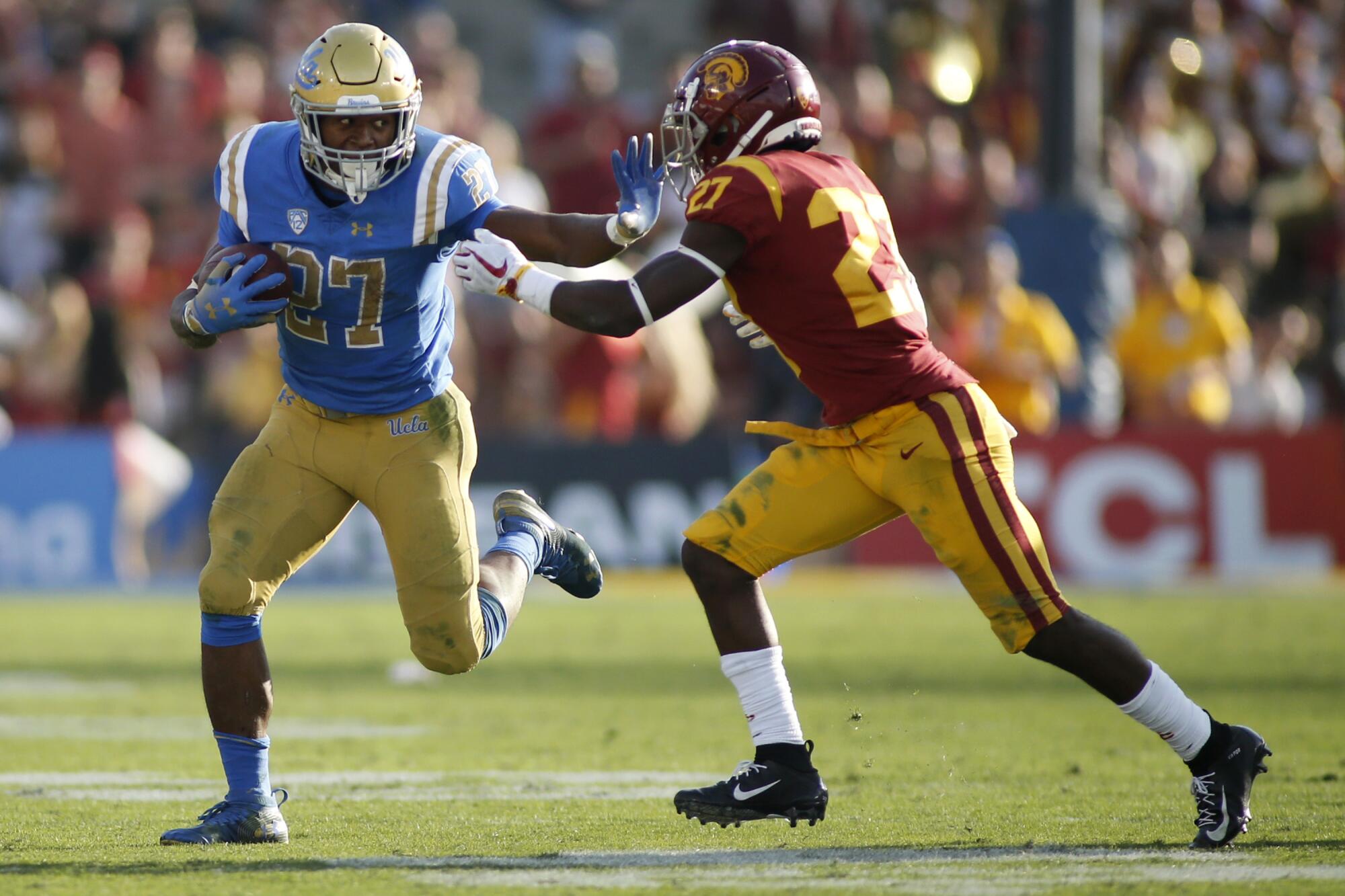 UCLA running back Joshua Kelley pushes off USC cornerback Ajene Harris during the Bruins' win over the Trojans